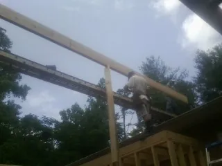 Carpenter setting a ridge beam over a new addition frame — Ice Dam Removal by Roofing Brothers in Waterloo